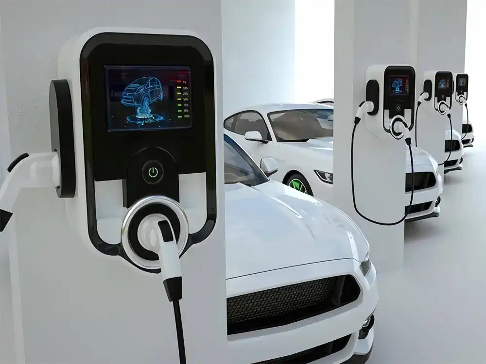 A line of white electric vehicles parked at smart charging pillars featuring digital status displays and integrated charging cables in a high-tech parking environment.